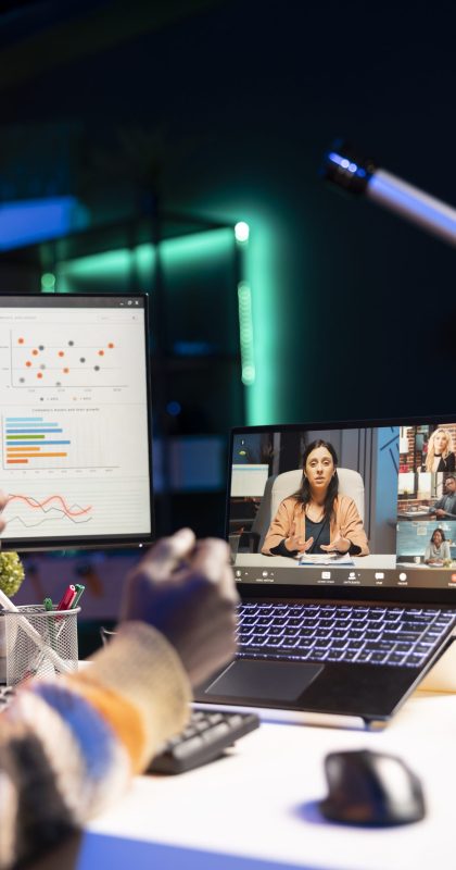 Black man using laptop to participate in online meetings Waving from his apartment, black man using laptop to participate in online meetings. Male freelancer uses wireless technology for video conferencing with colleagues to discuss work remotely.